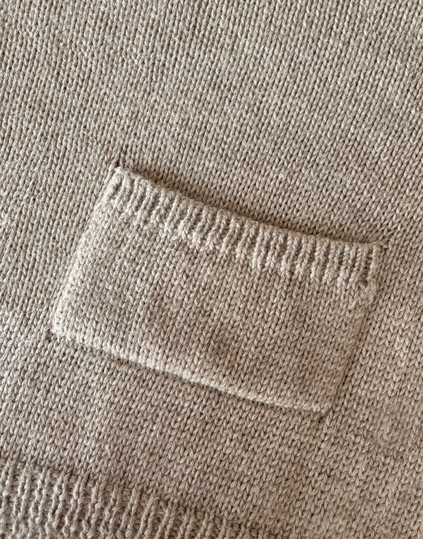 Close-up of the sweater pocket and knit texture.