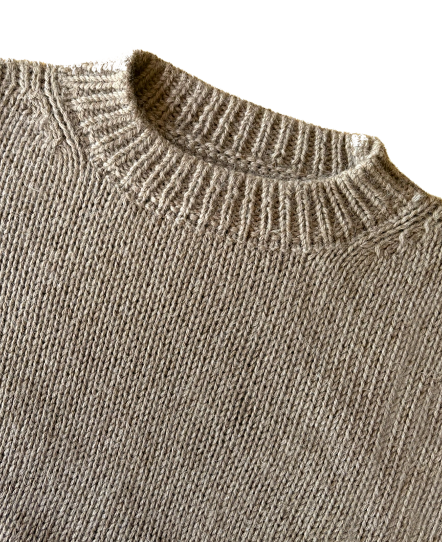 Close-up of the collar knit of the beige soft sweater.